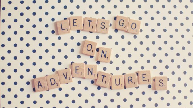 Wooden scrabble pieces that spell “Let’s go on adventures”.